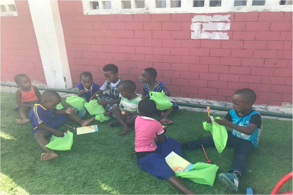 Children at RCC Playground looking at gift of School Materials provided to them by TIME TO HELP Foundation